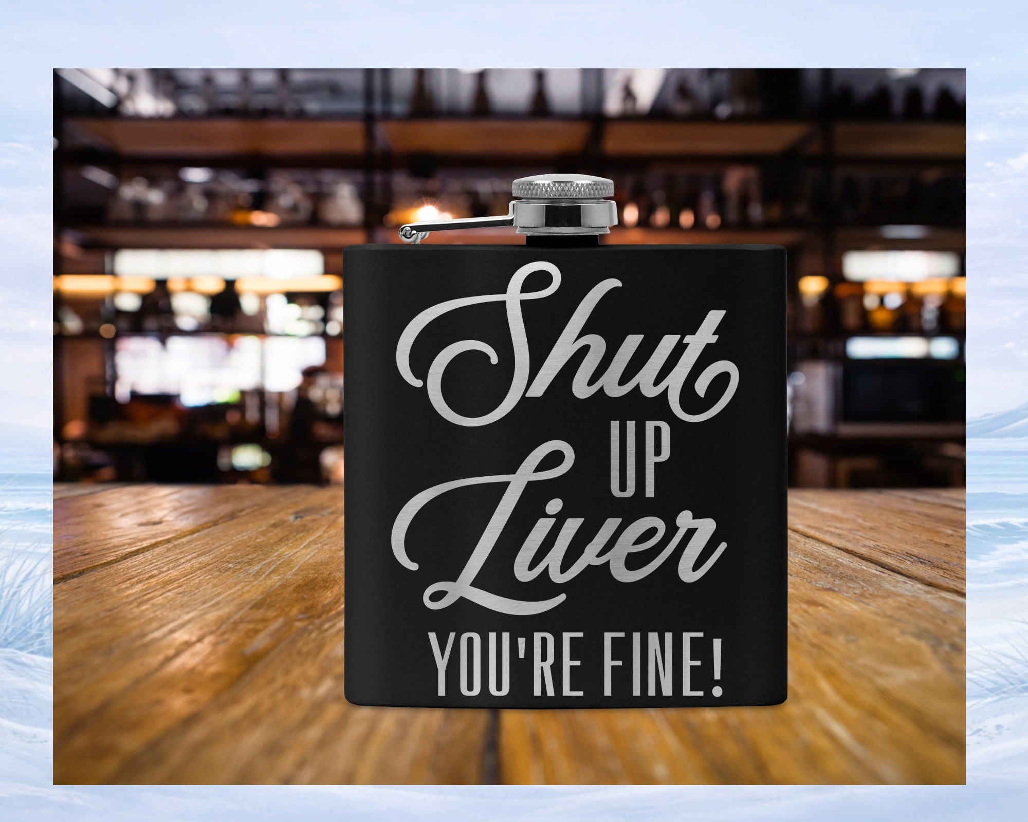 Black flask with "Shut Up Liver You're Fine!" text on wooden surface.