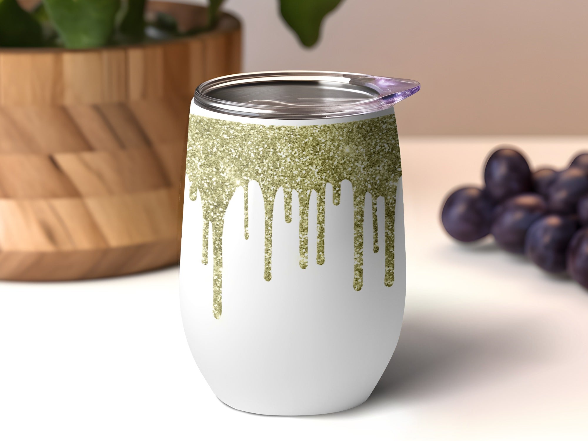 White tumbler with dripping gold glitter design and a purple lid.