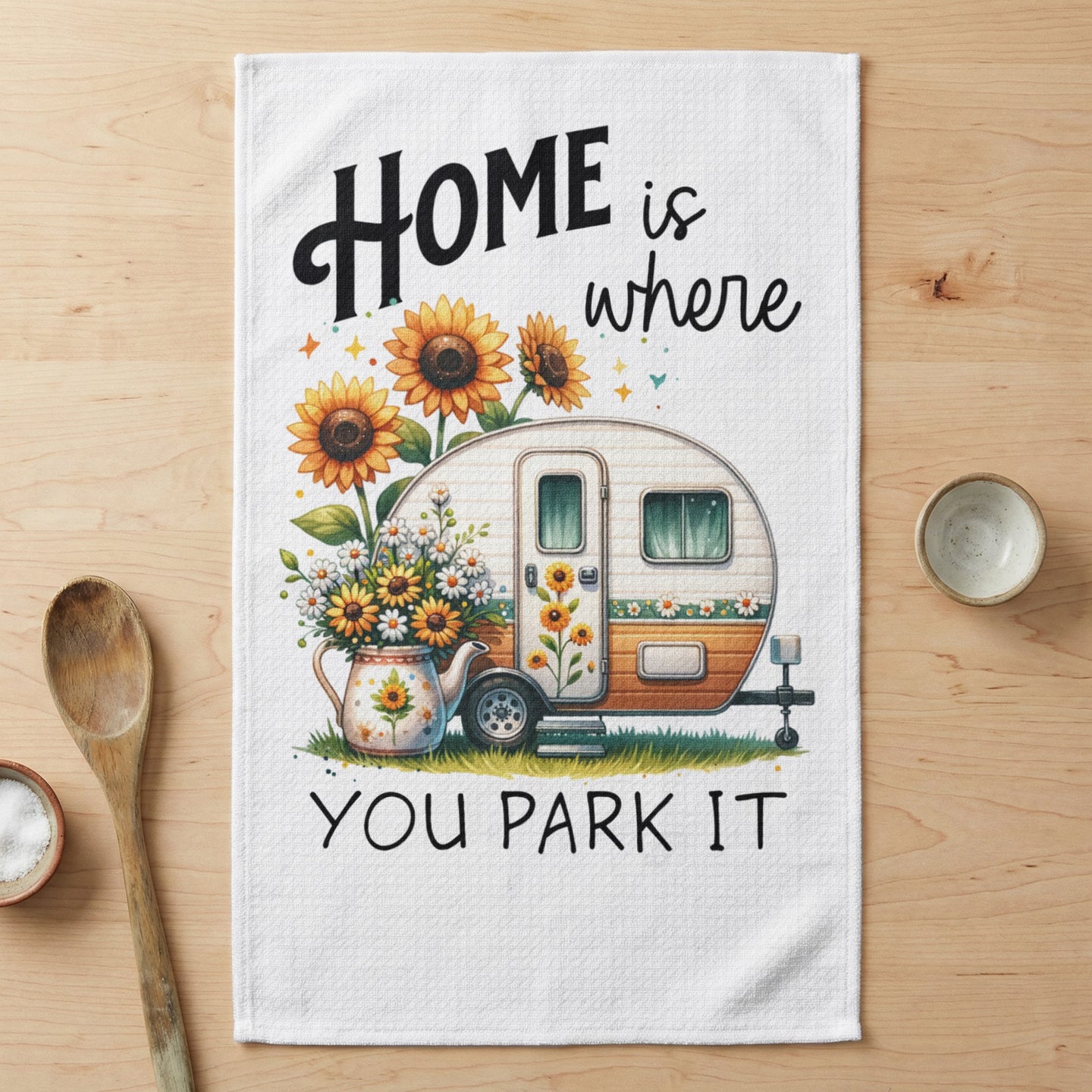 Camper trailer with sunflowers and "HOME is where YOU PARK IT" text.