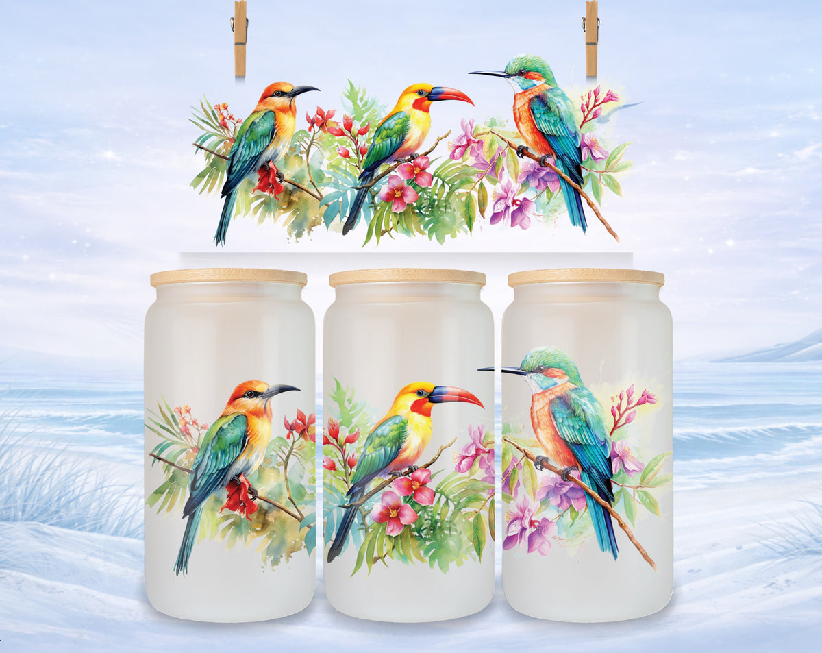 Three glass jars with hummingbird designs and wooden lids, set against a snowy landscape.