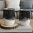 Black and white floral and celestial pattern insulated tumblers on wooden coaster.
