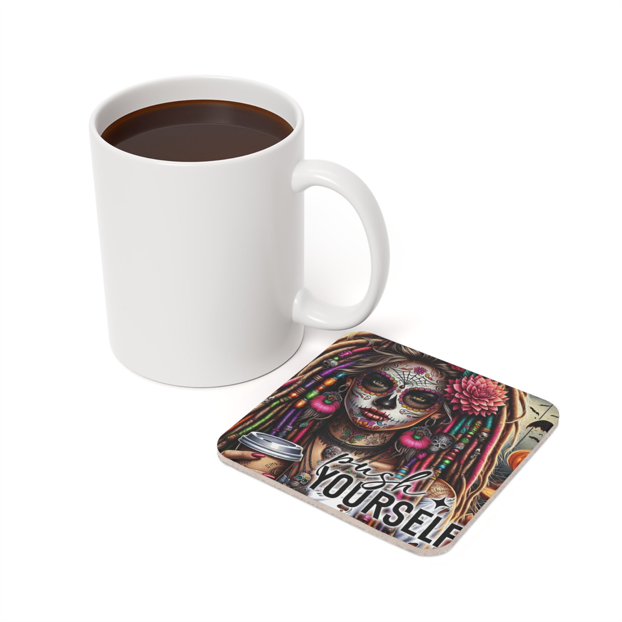 White mug of coffee next to a coaster with a Day of the Dead inspired woman.