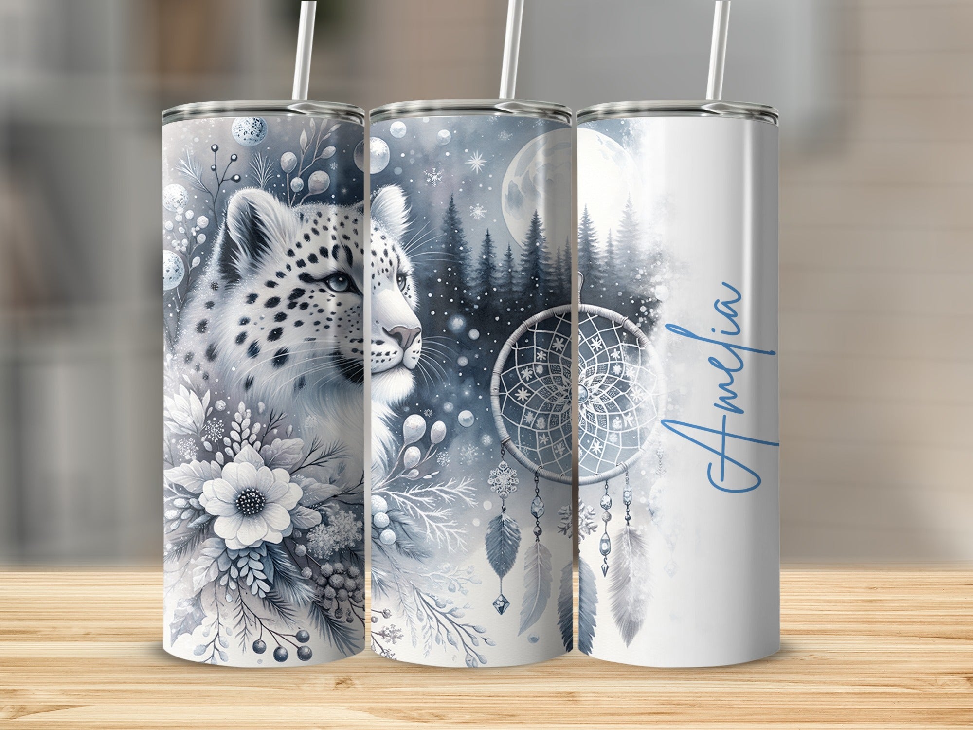 Snow leopard and dreamcatcher design on three skinny tumblers with blue text "Amelia".