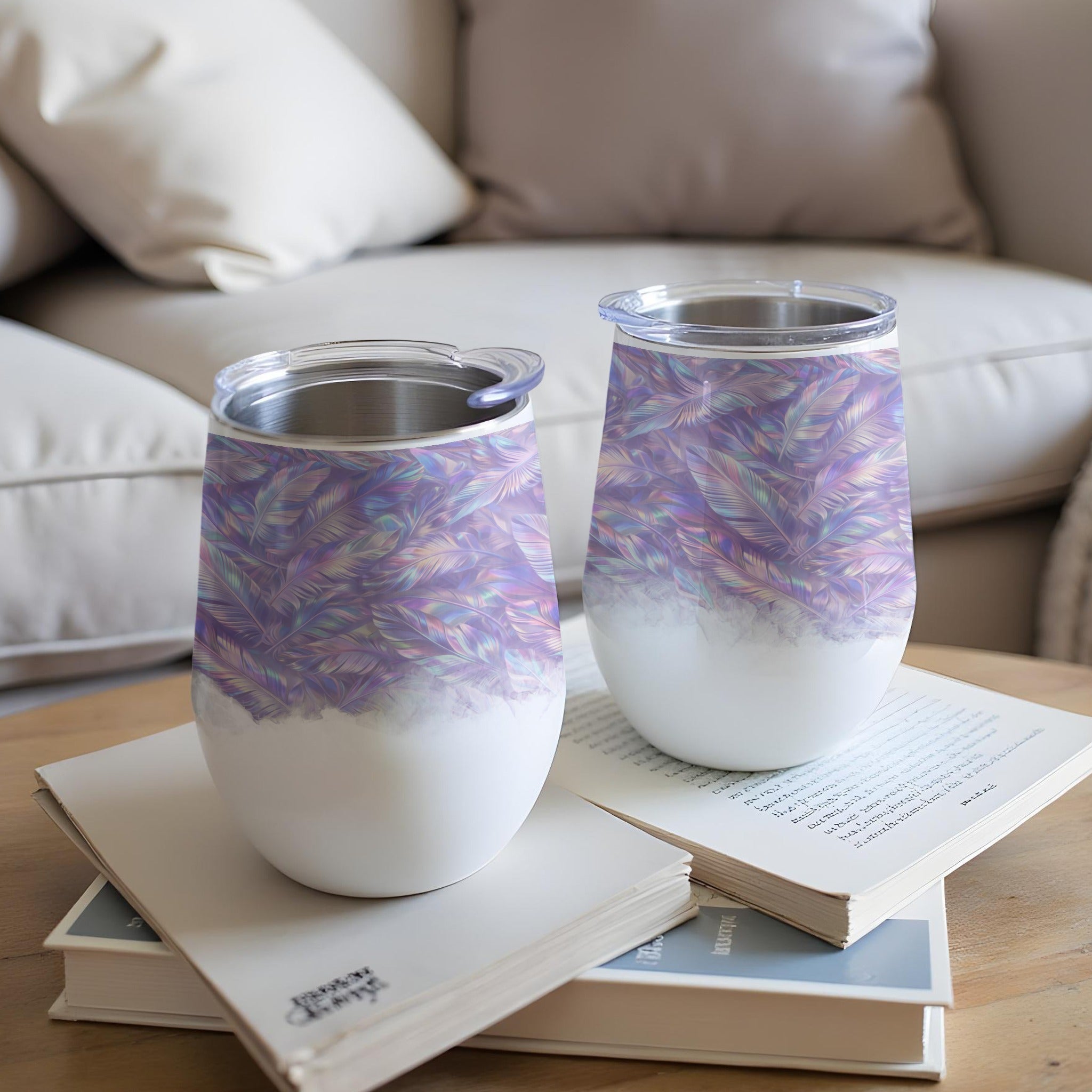 Two wine tumblers with a feathered pattern sit on a book.