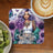 Woman with purple hair and tattoos, floral background, text "Dream Big Never Give Up".