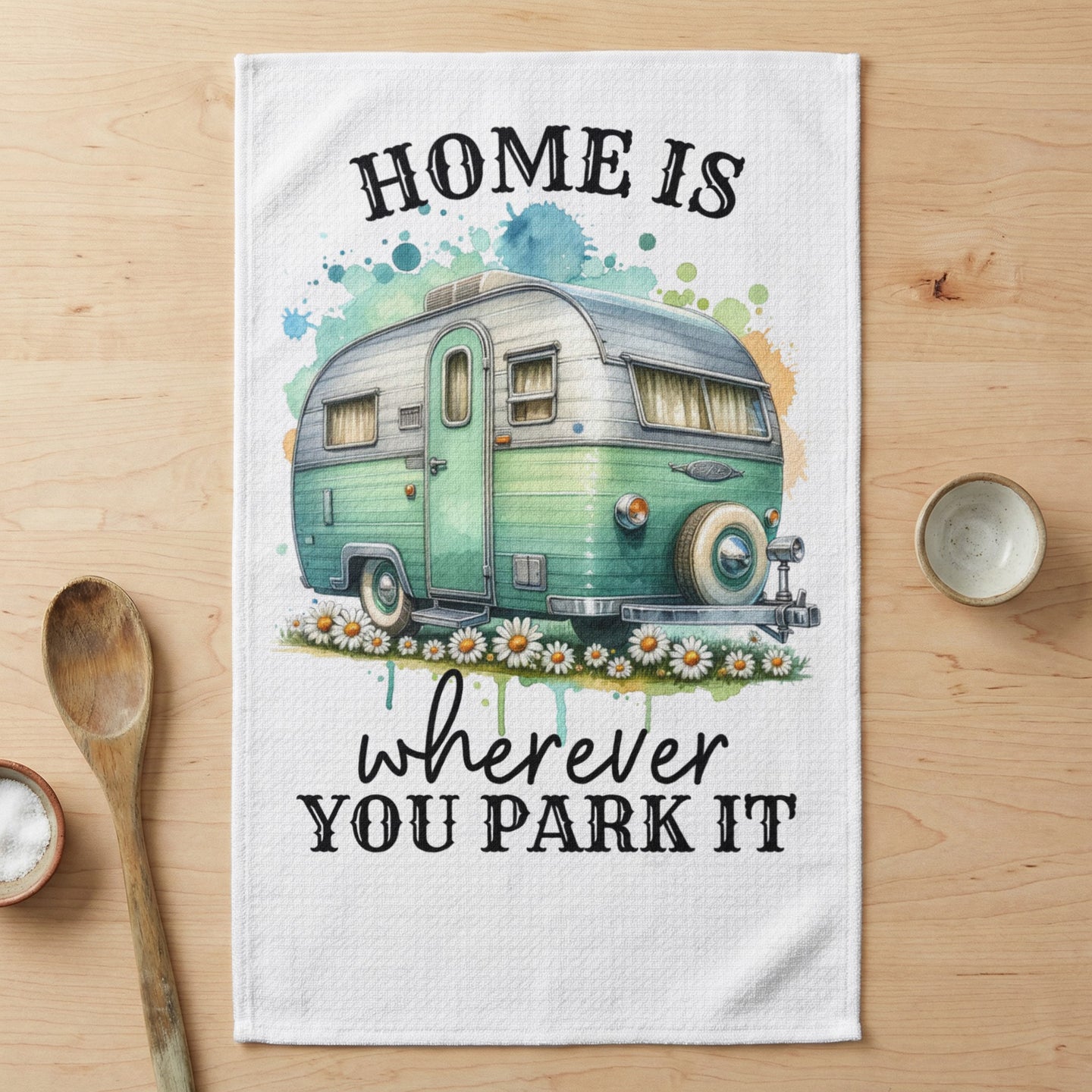 Green camper trailer with "HOME IS wherever YOU PARK IT" text.