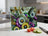 Hummingbird and flowers cutting board with tomatoes and cucumber slices.