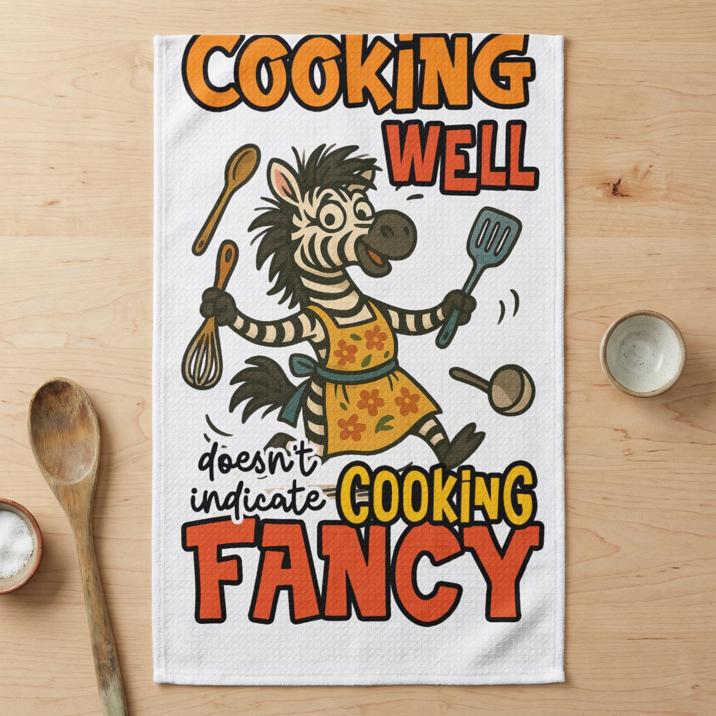 Zebra wearing apron, whisking and holding spatula, with text "COOKING WELL doesn't indicate COOKING FANCY".