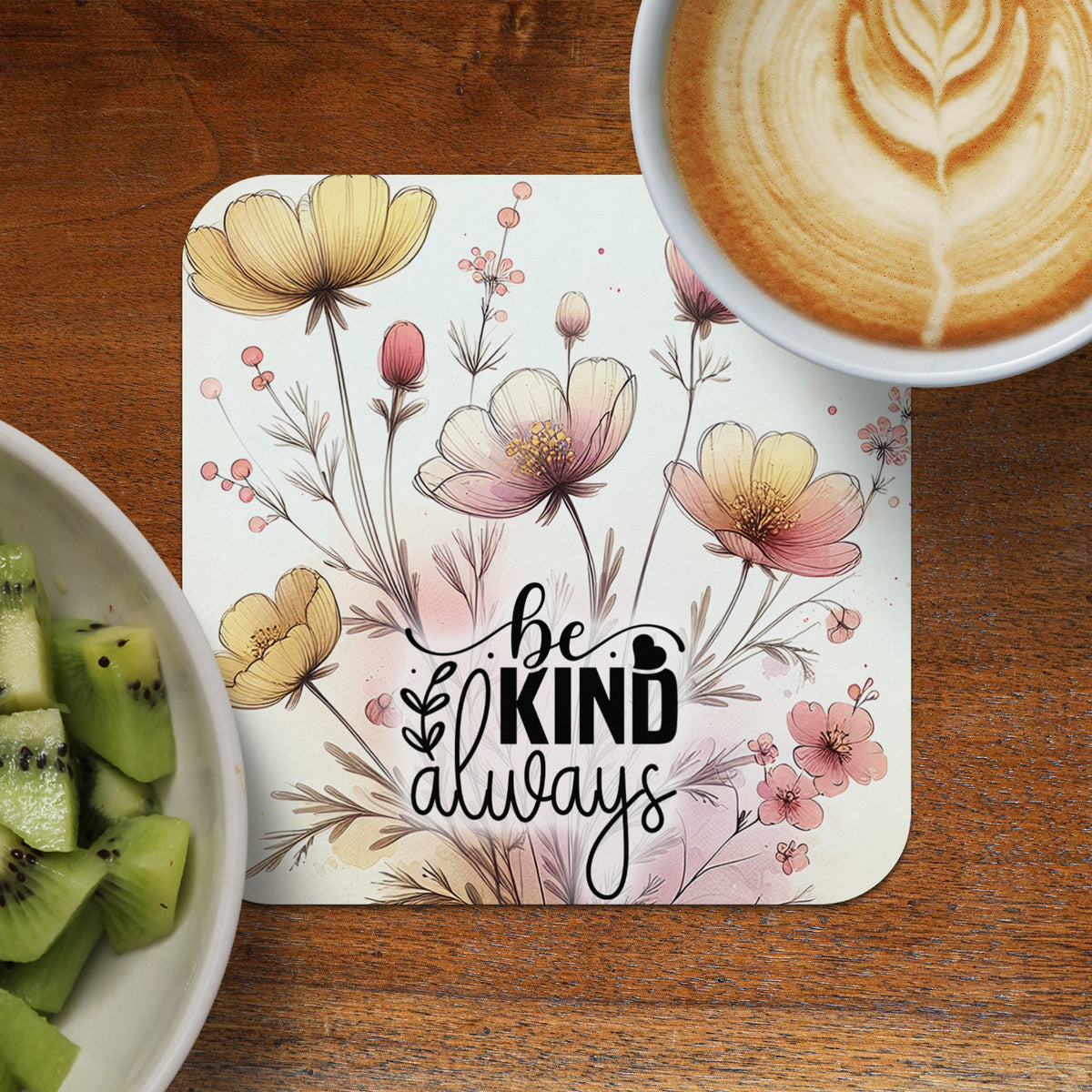 Floral coaster with "be kind always" handwritten text and coffee cup.