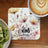 Floral coaster with "be kind always" handwritten text and coffee cup.