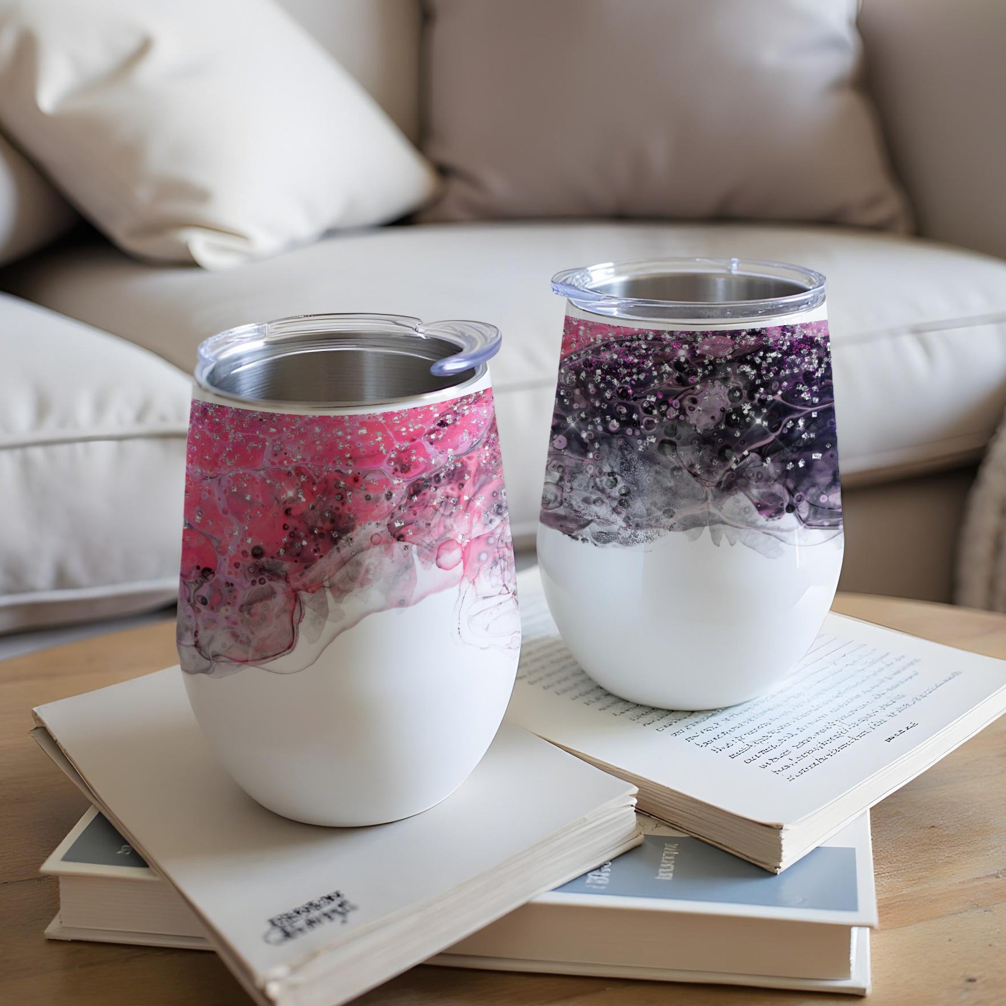 Two white stemless wine tumblers with marbled pink and purple designs.