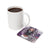 White mug next to a coaster with a skull-wearing woman and text "WHO RUNS THE WORLD?".