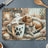 Mug with paw print next to sleeping dog and cat in cozy setting.
