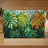 Monstera leaves in shades of green, yellow, and orange against stained glass.