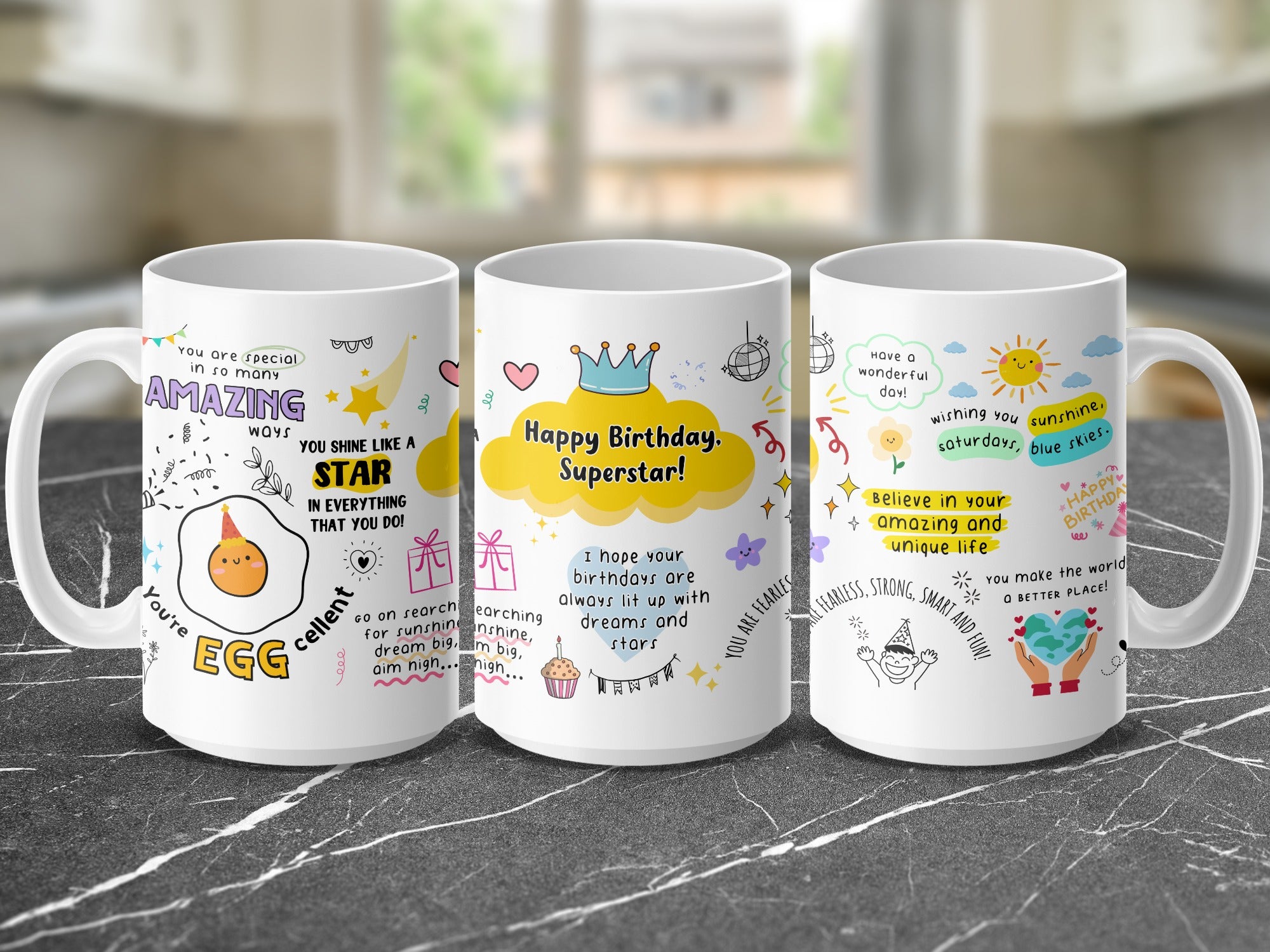 Three mugs decorated with colorful birthday messages and whimsical illustrations of stars and suns.