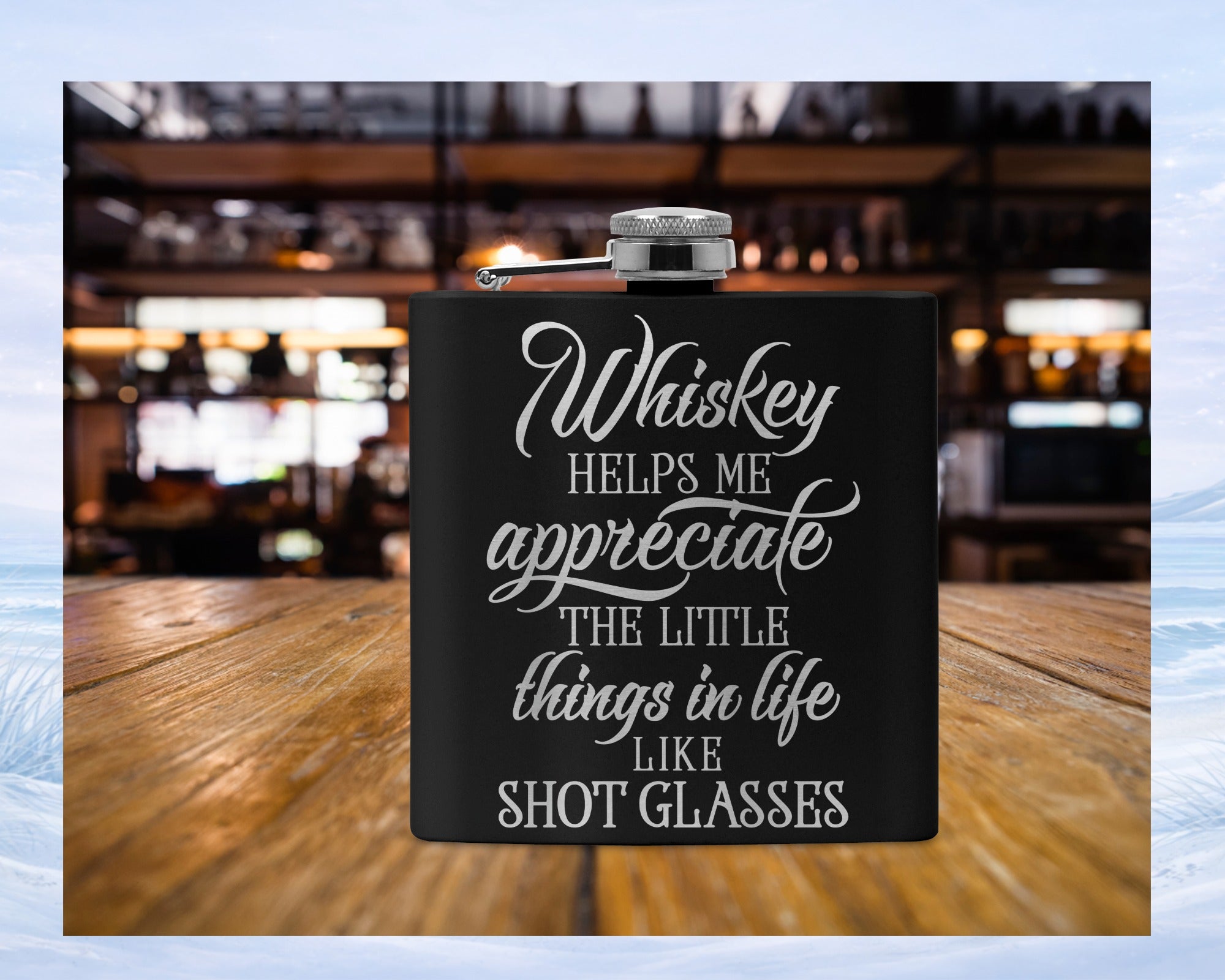 Black flask with white text reading "Whiskey helps me appreciate the little things in life like shot glasses".