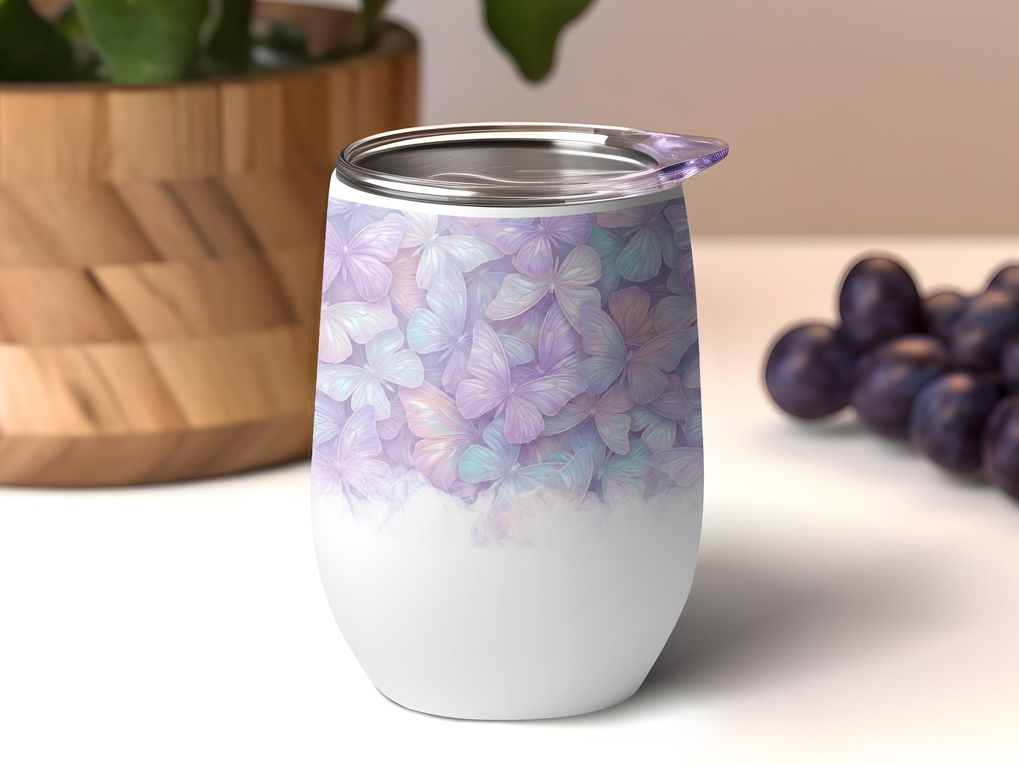 White tumbler with pastel floral pattern, lid, and grapes in background.