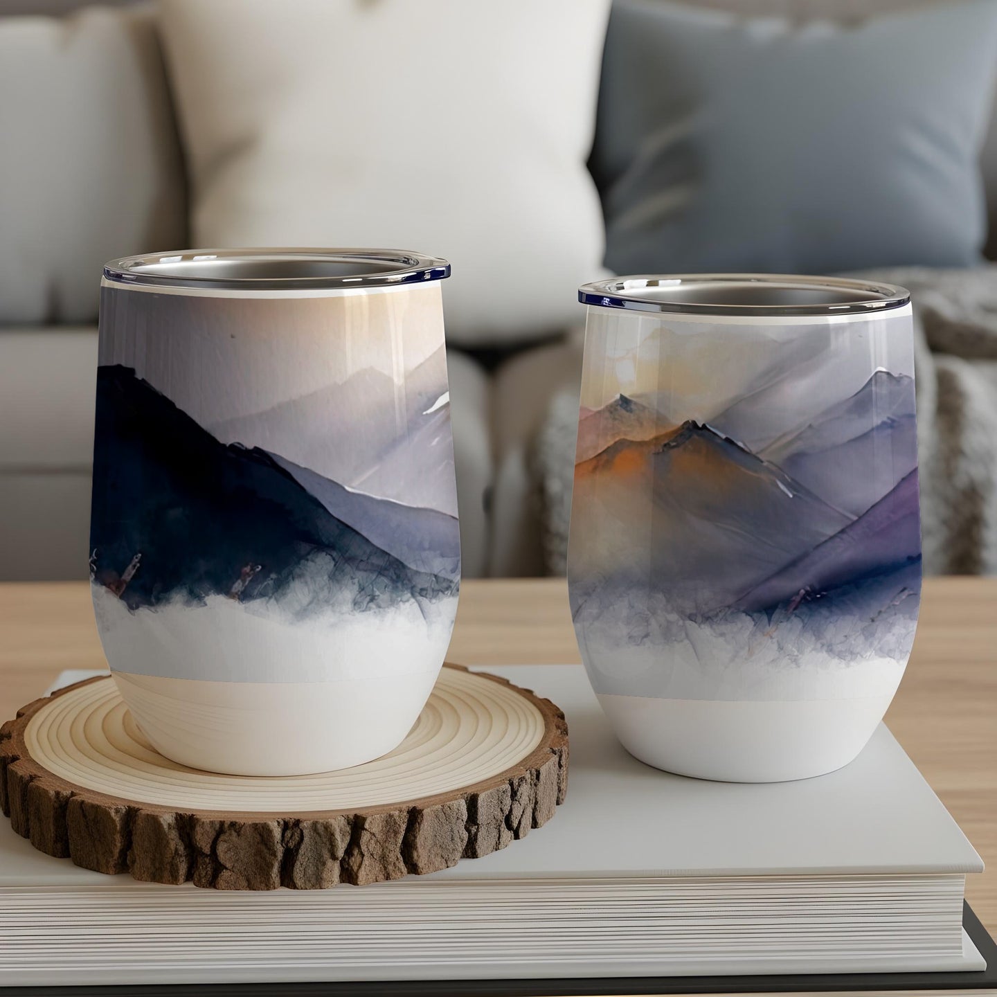 Two insulated tumblers with abstract mountain watercolor designs.