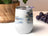 White tumbler with a tropical beach scene and grapes on the side.