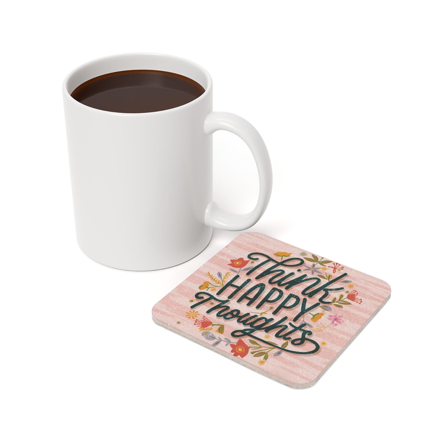 White mug of coffee next to a coaster that reads "Think Happy Thoughts".