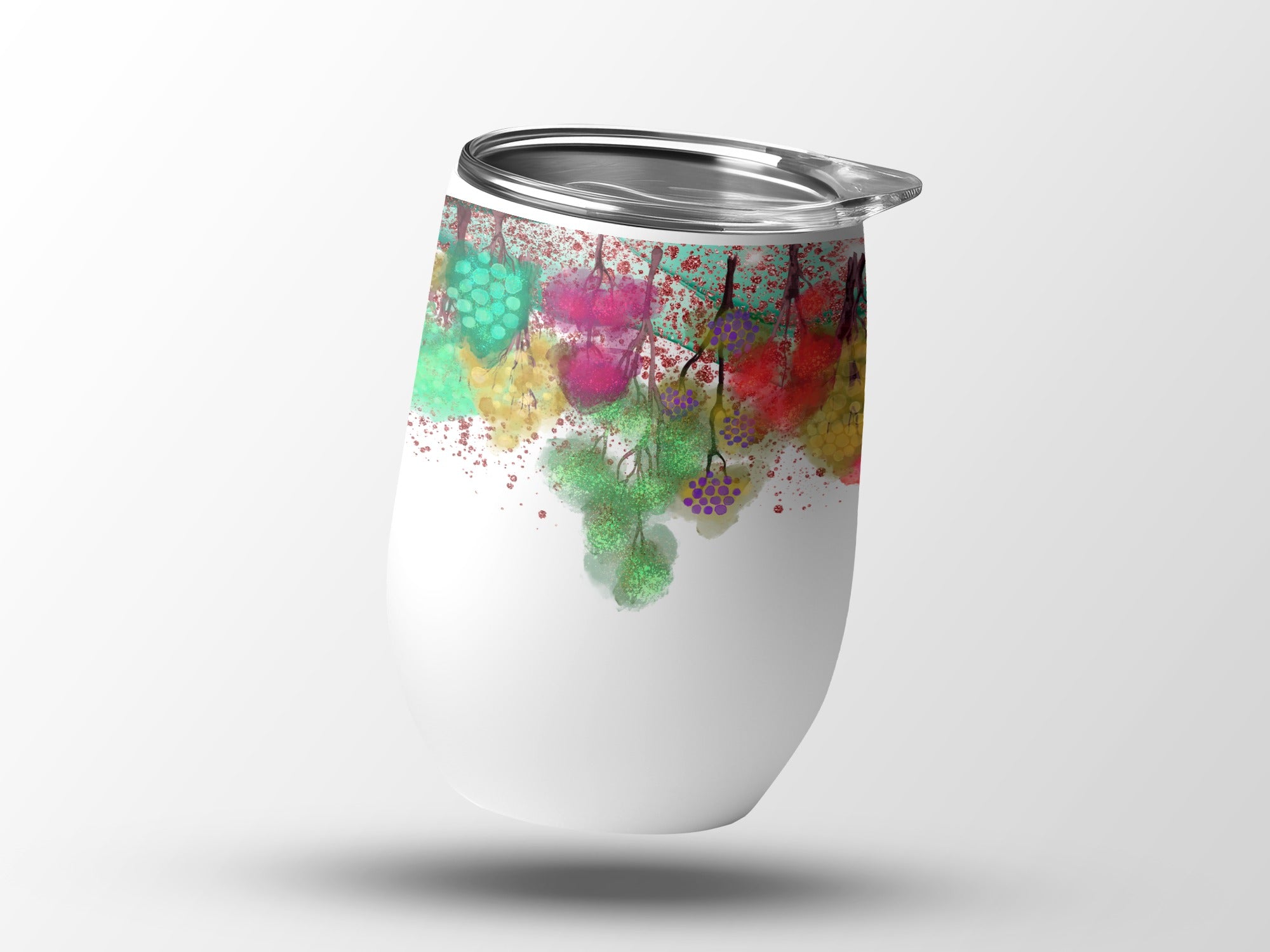 White tumbler with colorful berry pattern and silver lid, floating.