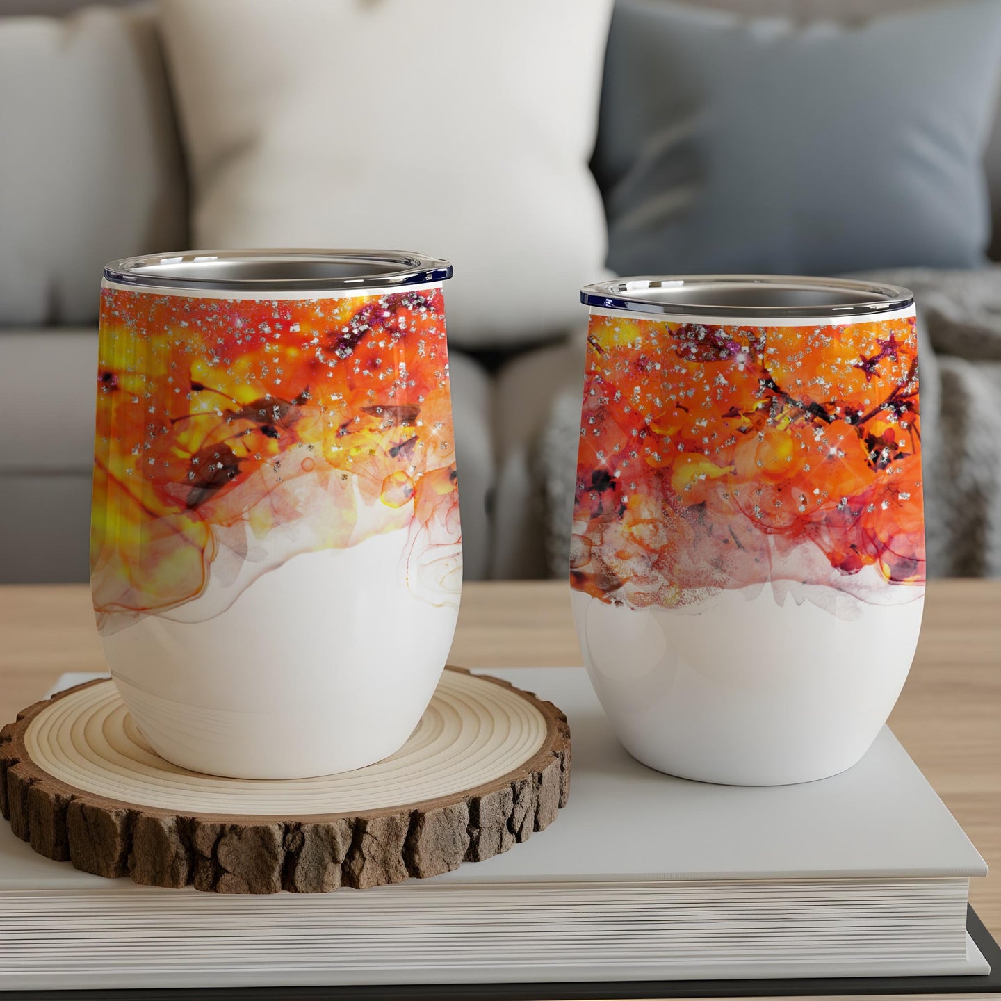 Two white tumblers with abstract orange, yellow, and red fluid art.