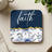 Square coaster with "faith" text and blue floral design.