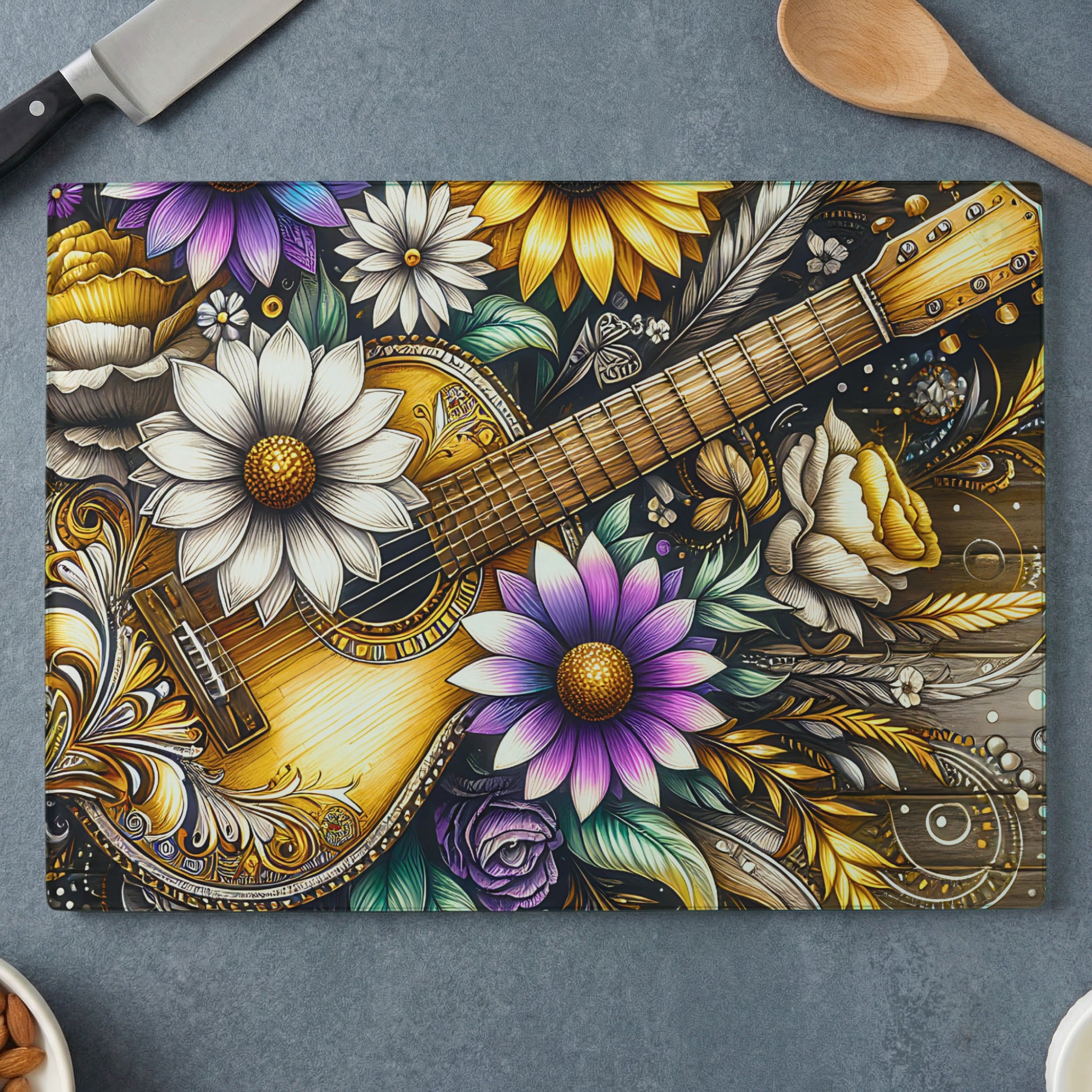 Acoustic guitar nestled among colorful floral designs on a cutting board.