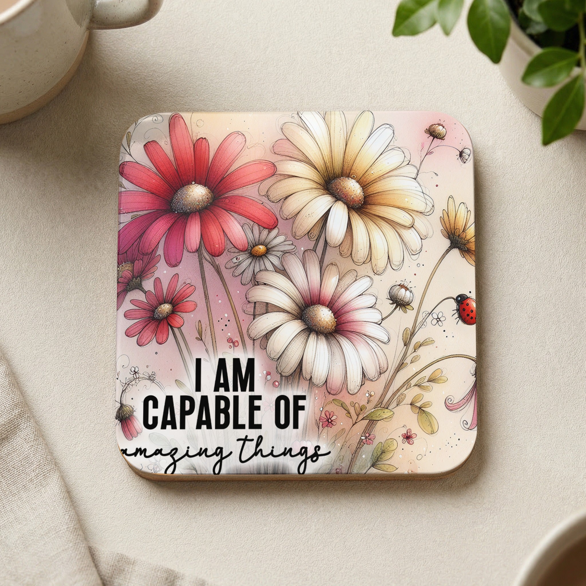 Coaster with flowers and ladybug, reading "I AM CAPABLE OF amazing things".