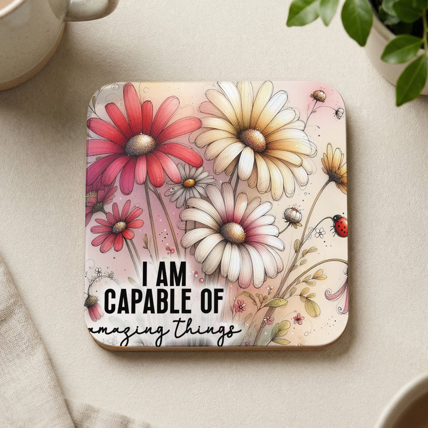 Coaster with flowers and ladybug, reading "I AM CAPABLE OF amazing things".