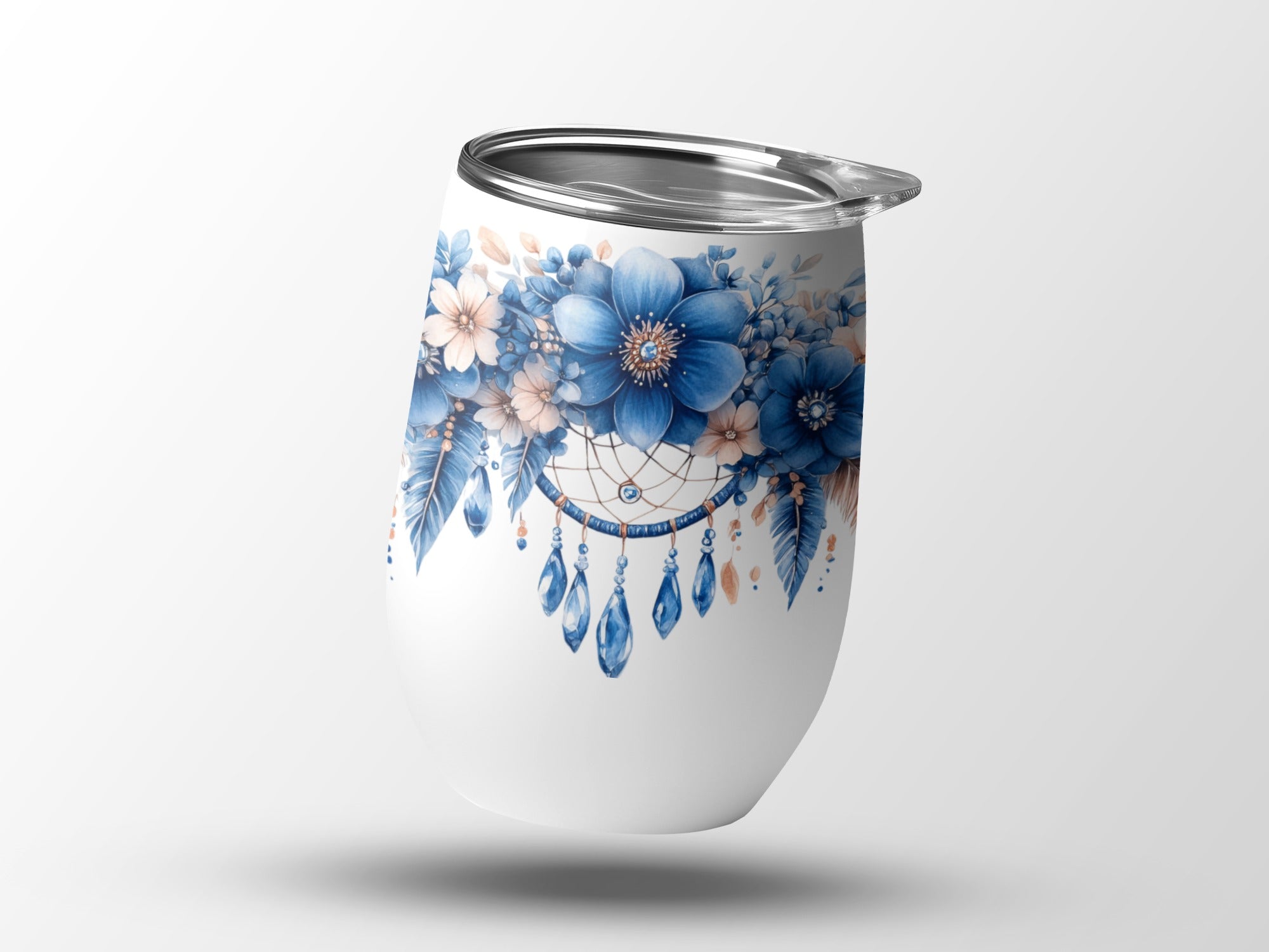 White tumbler with blue floral dreamcatcher design and hanging beads.