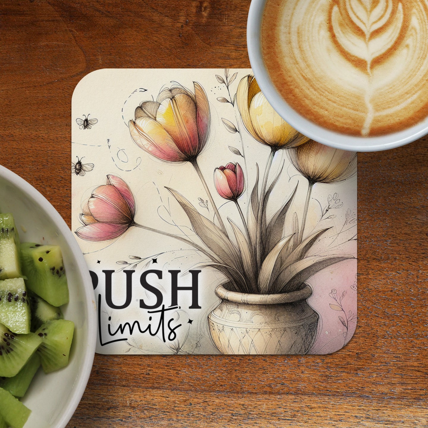Floral illustration with "PUSH Limits" text on a coaster next to kiwi and coffee.