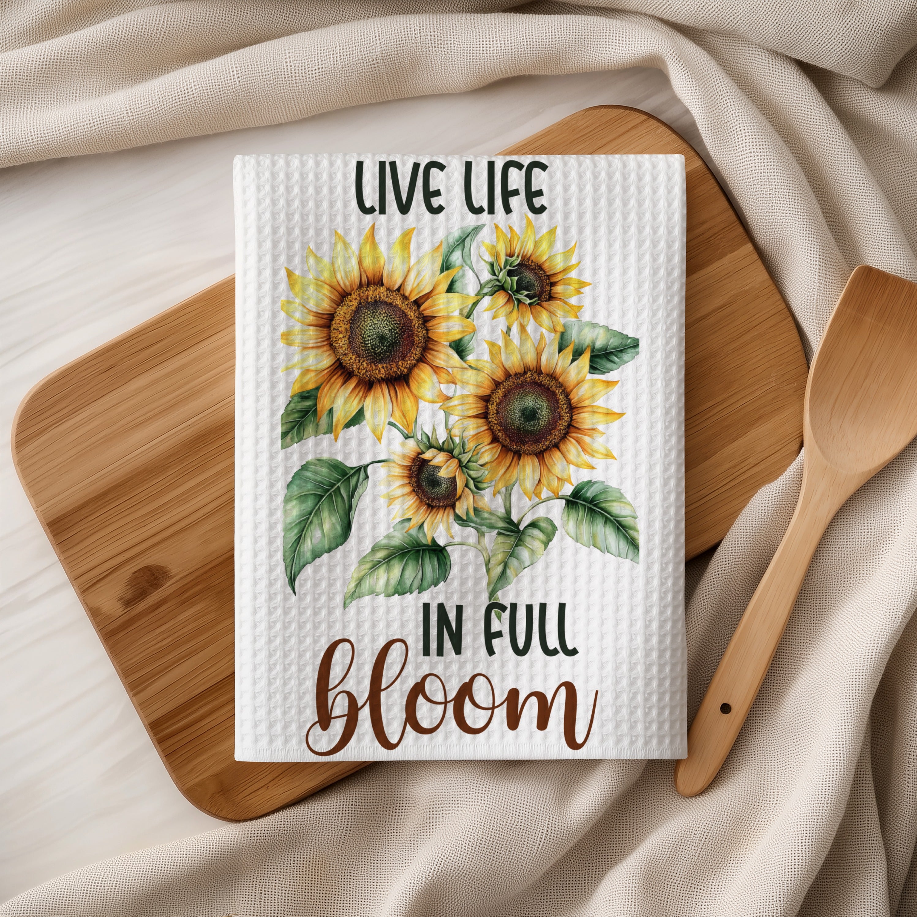 Kitchen towel with sunflowers and "Live life in full bloom" text.