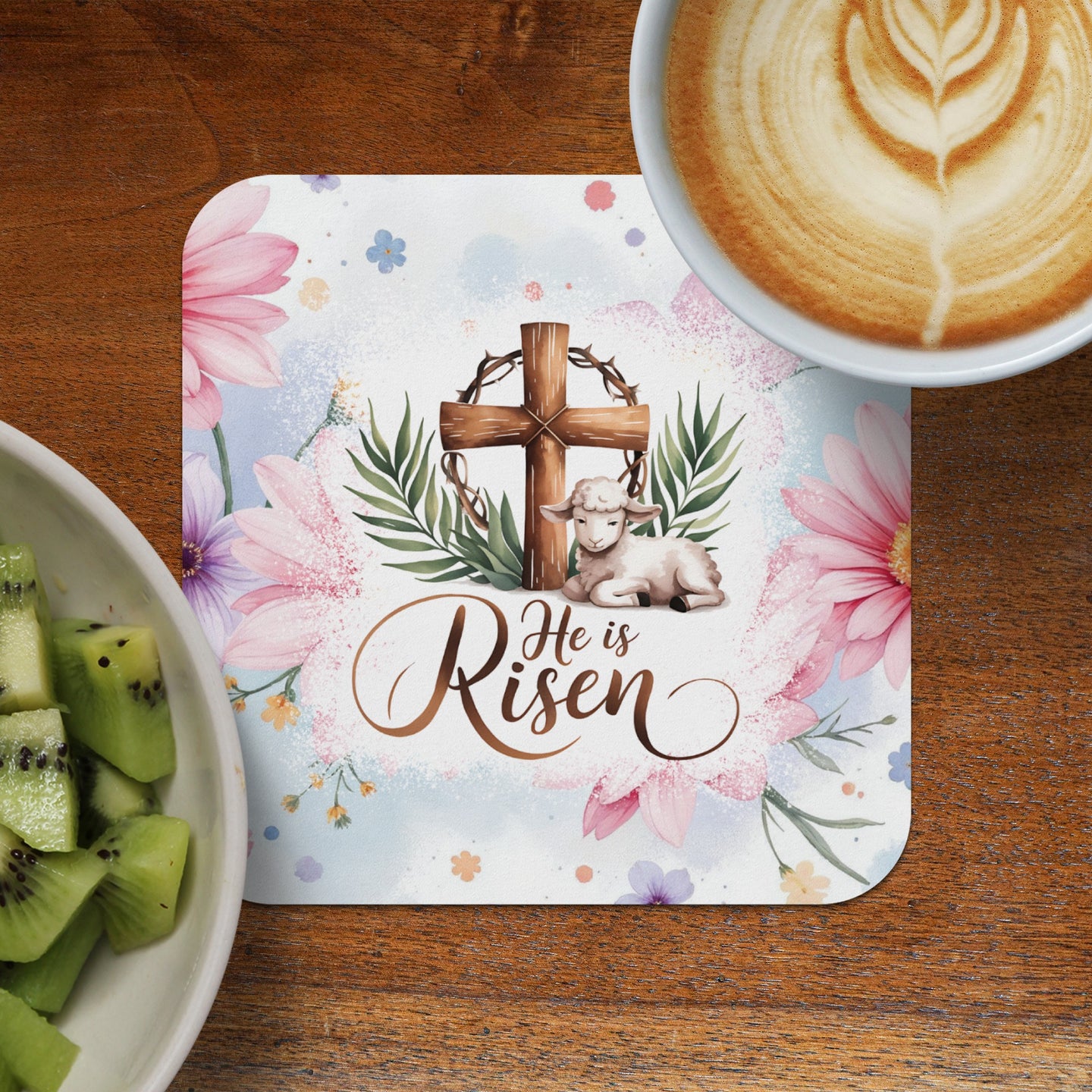 Coaster with wooden cross, lamb, and text "He is Risen" surrounded by flowers.