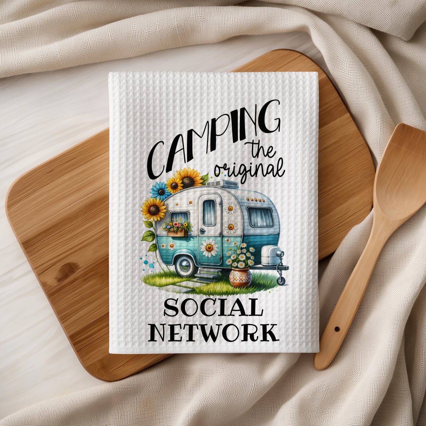 Tea towel with turquoise camper, sunflowers, and "Camping the original social network" text.