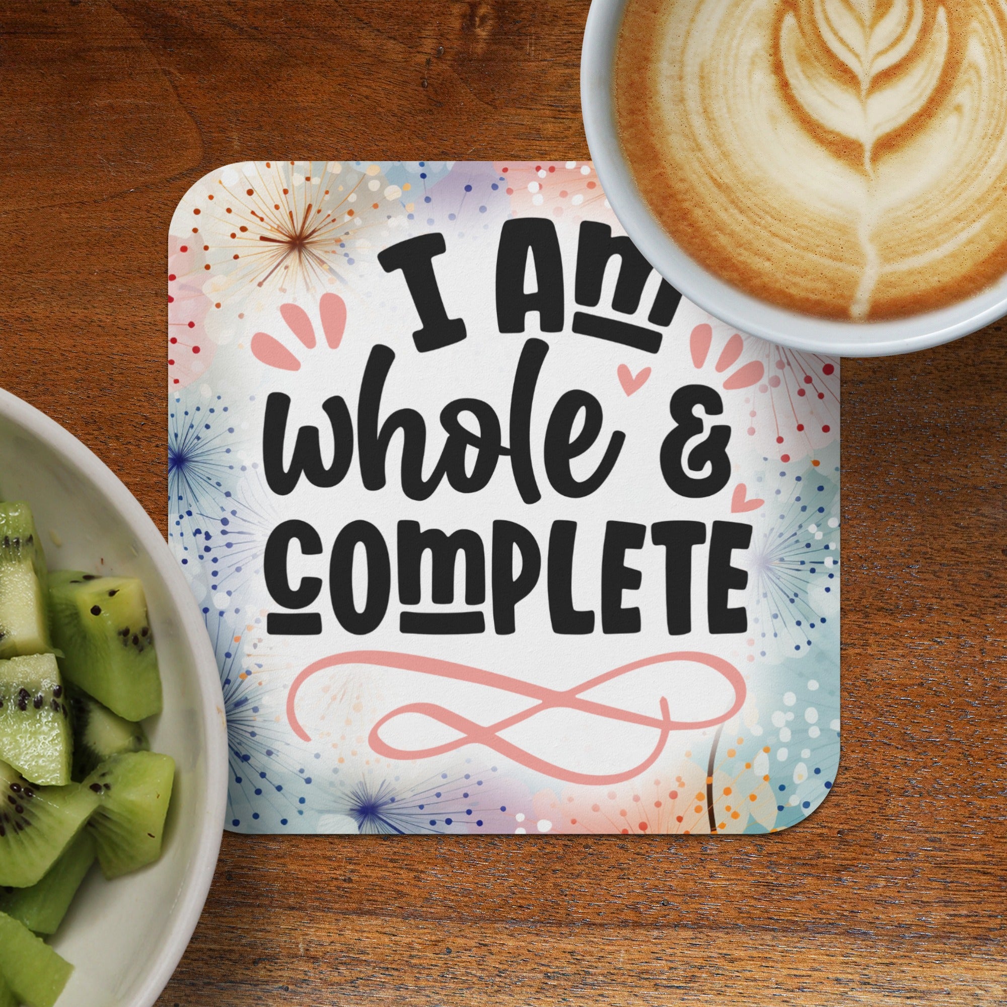 Coaster with "I am whole & complete" text, kiwi slices, and coffee.