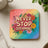 Square coaster with "Never Stop Dreaming" text and colorful rainbow background.