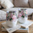 Two white stemless wine tumblers with pink floral designs and an initial "A".