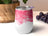 White tumbler with pink abstract alcohol ink design.