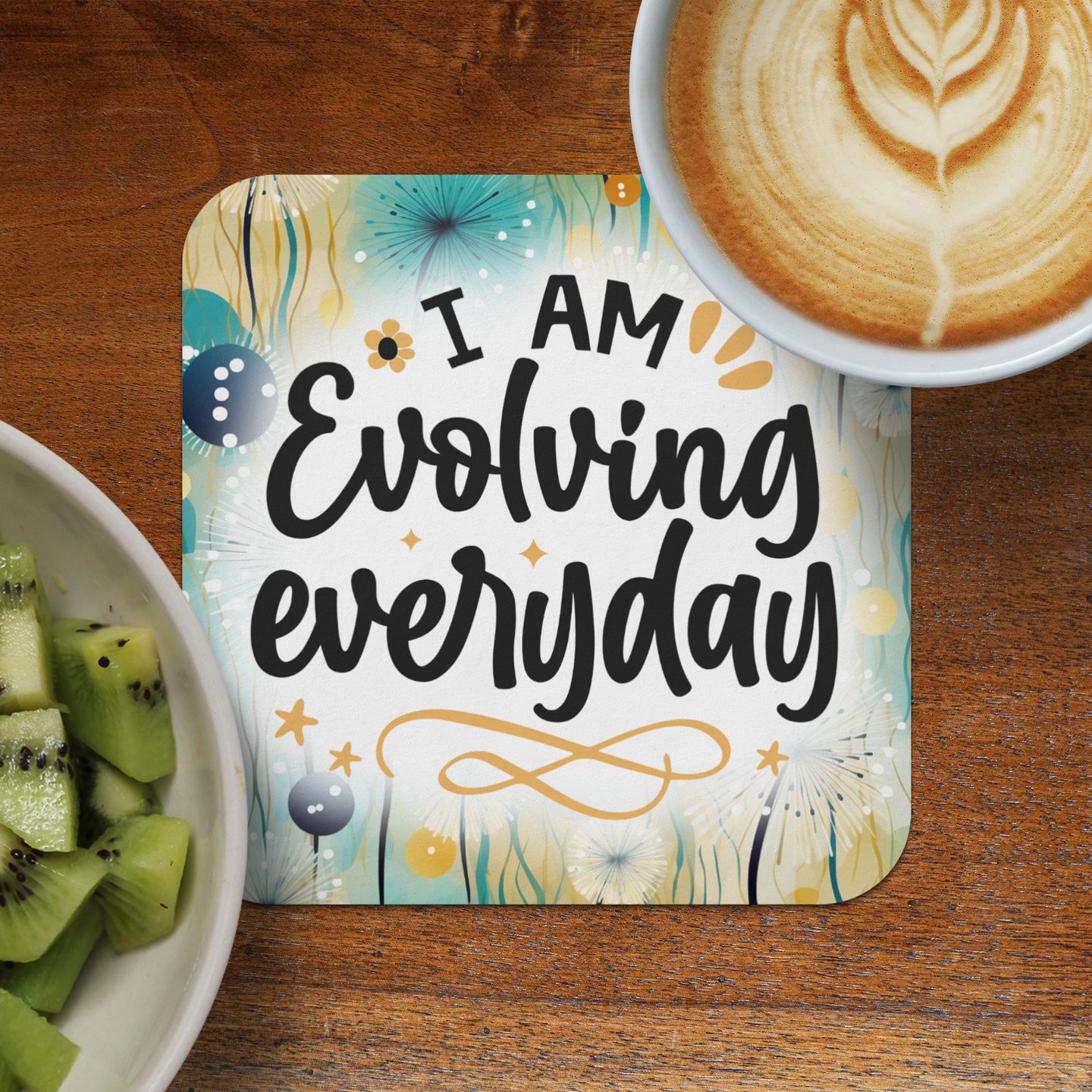 Coaster with "I AM Evolving everyday" text and latte art coffee cup.