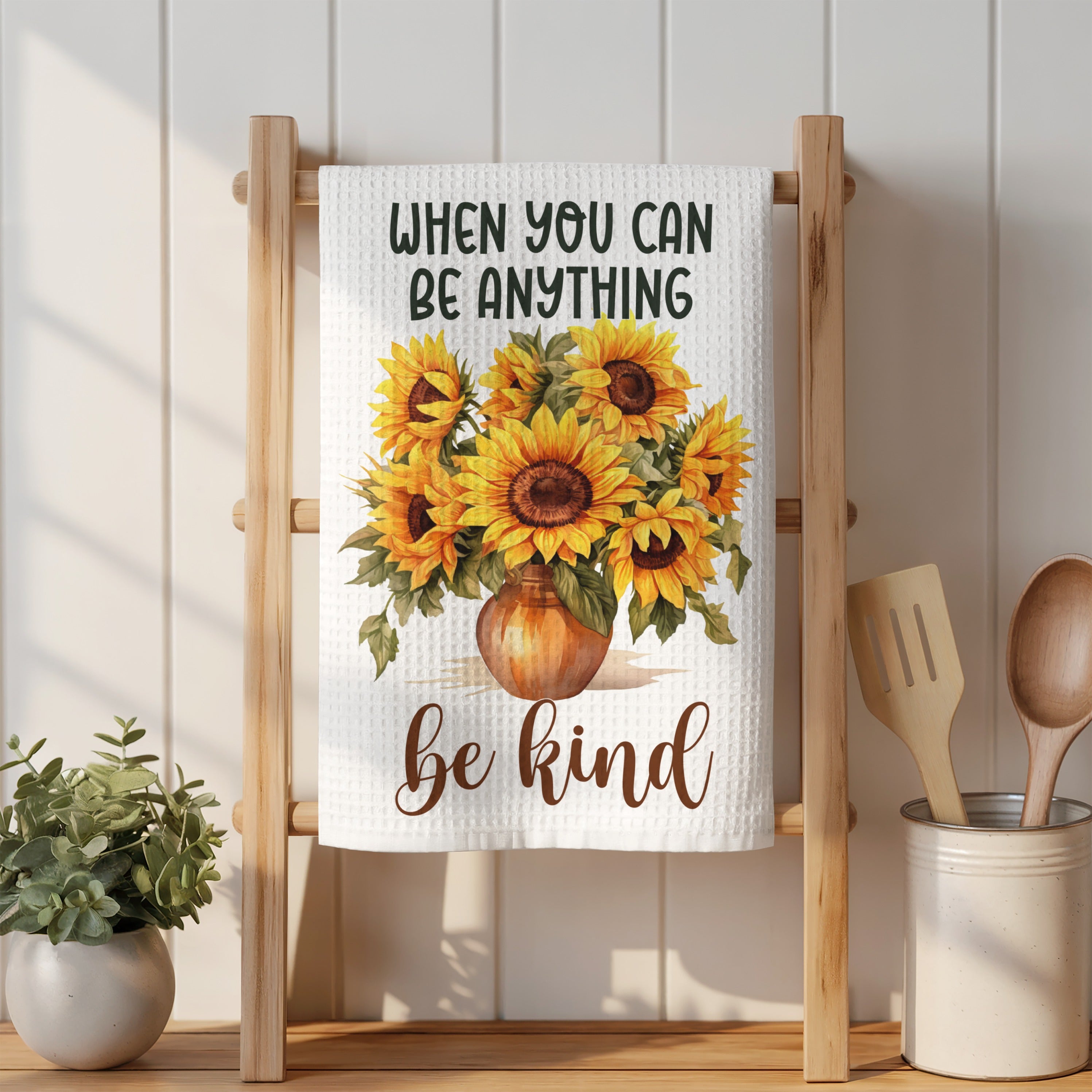 Towel with sunflowers and "When you can be anything, be kind" text.