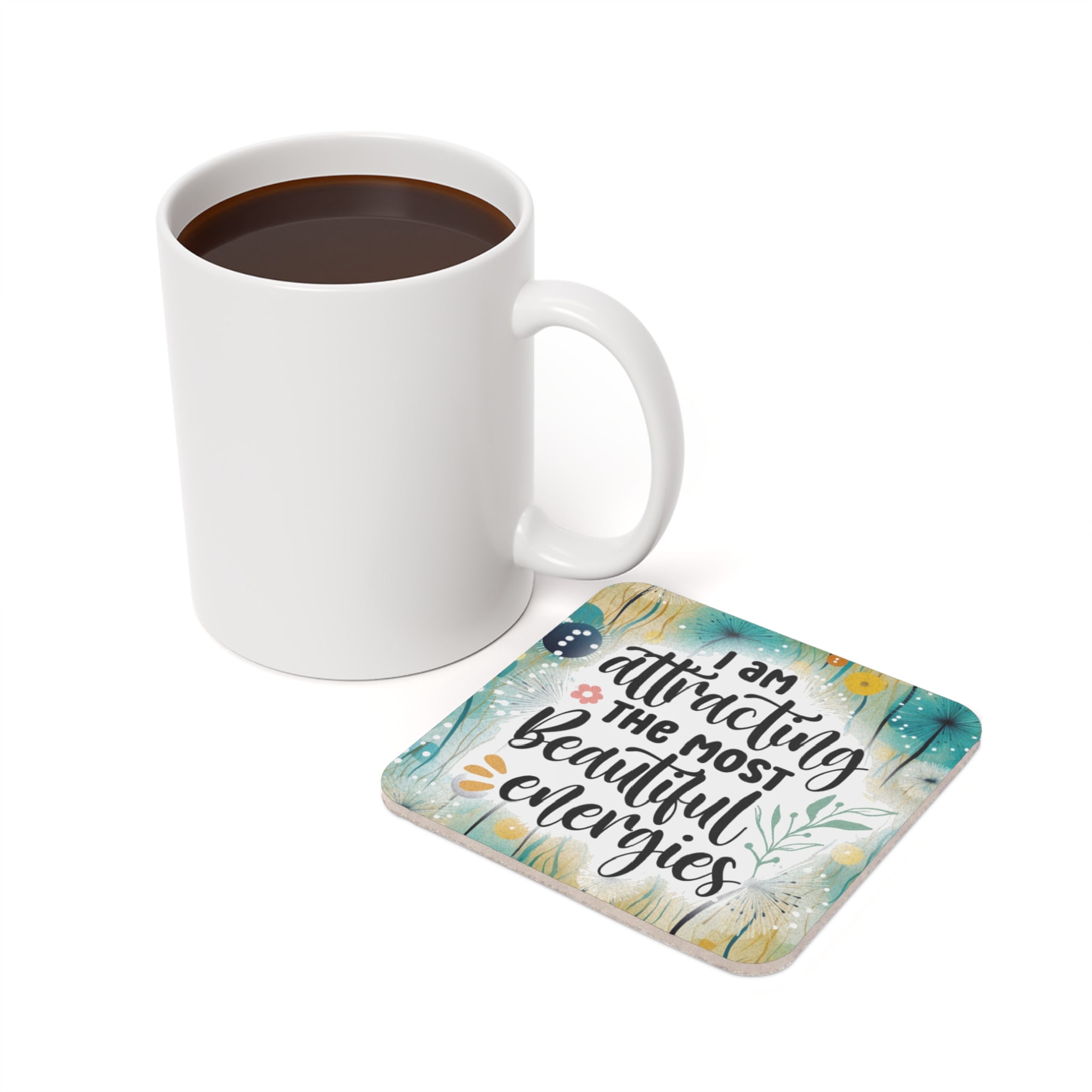 White mug and coaster with "I am attracting the most beautiful energies" text.
