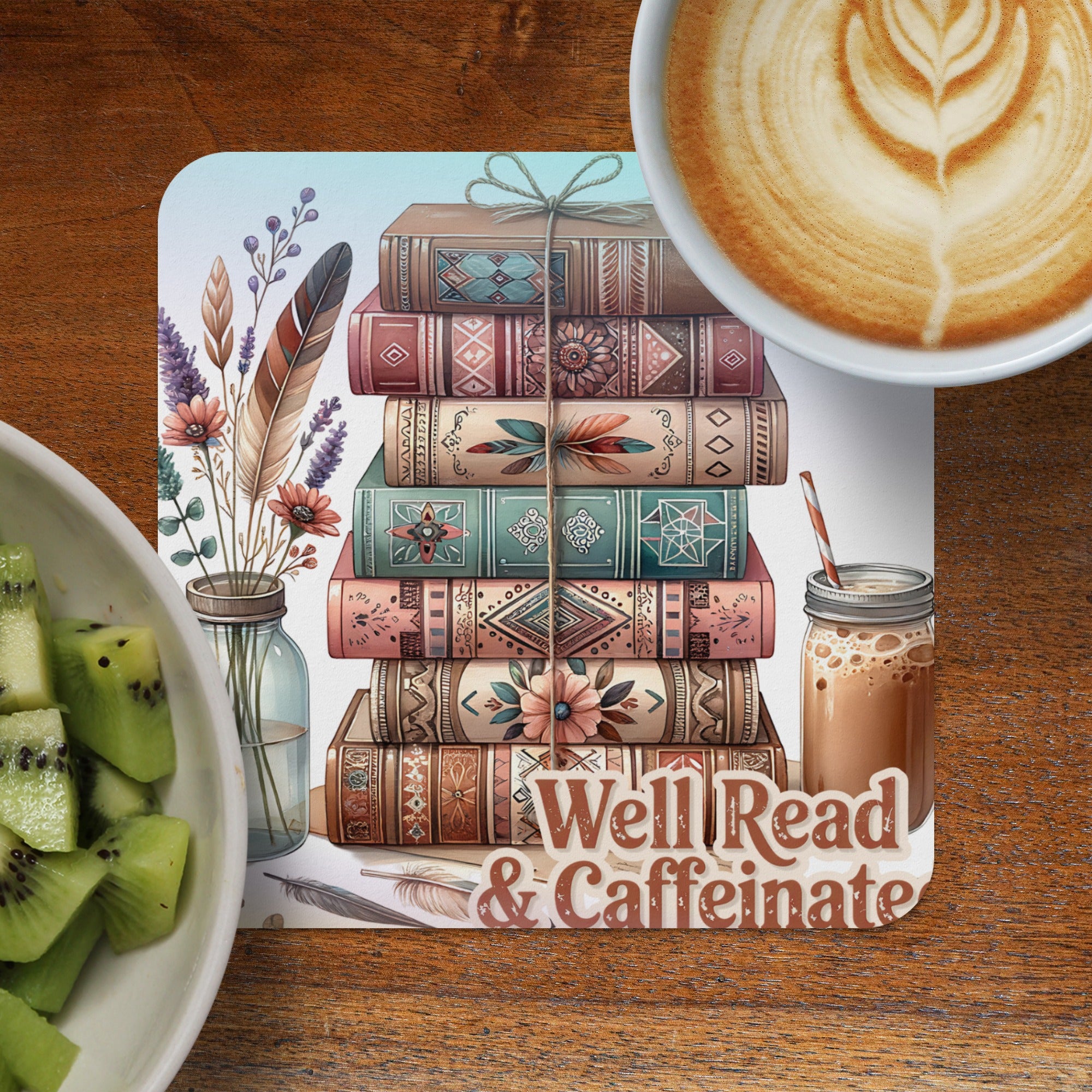 Stack of decorative books with feathers and text "Well Read & Caffeinate".