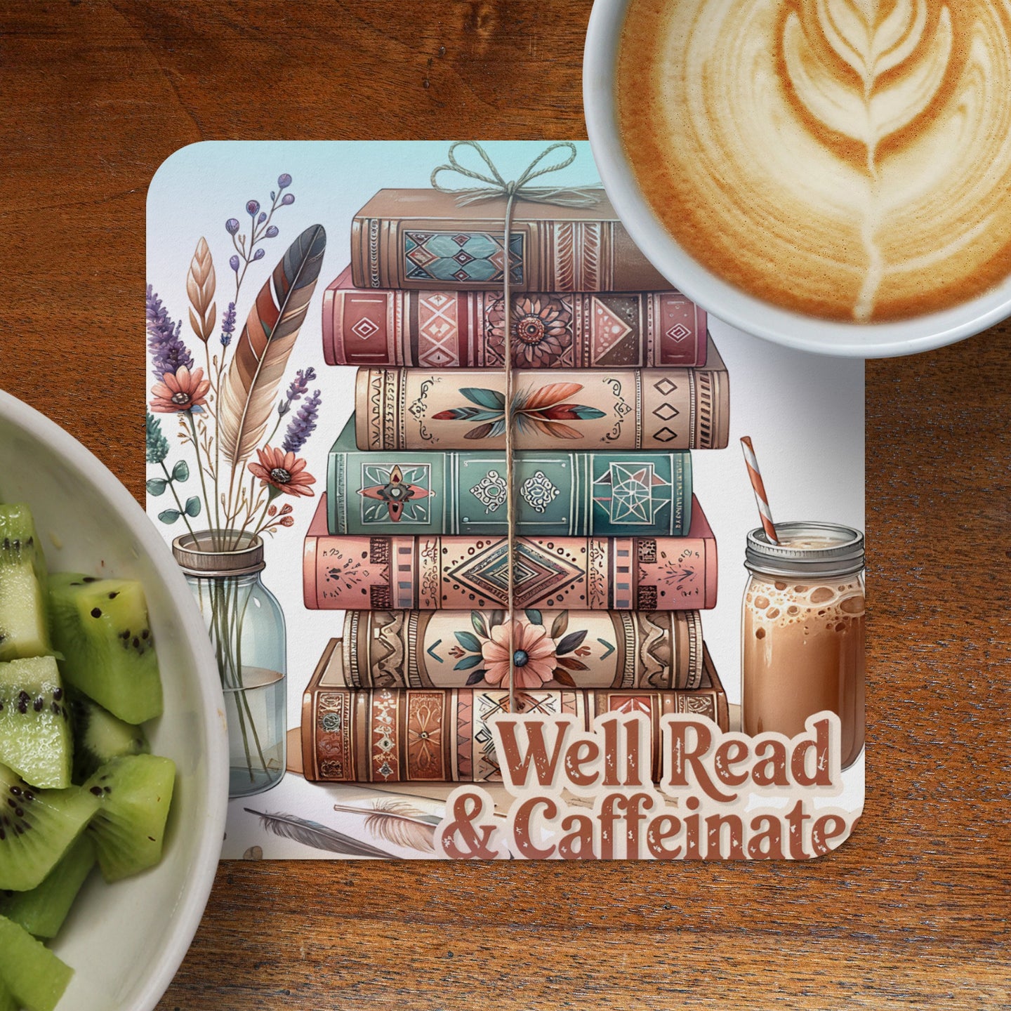 Stack of decorative books with feathers and text "Well Read & Caffeinate".