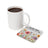 White coffee mug next to square coaster with floral design and "FOLLOW YOUR dreams" text.