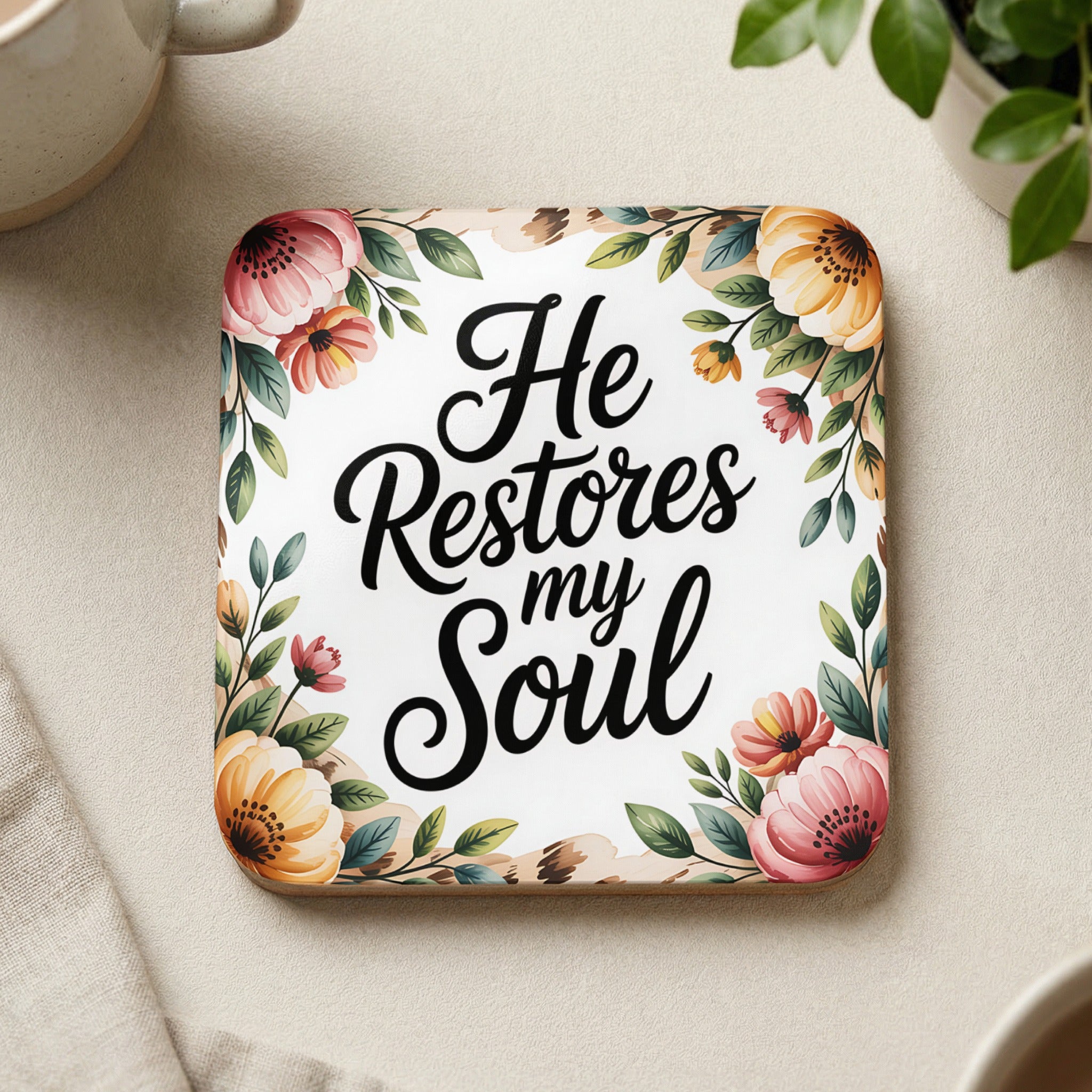 Square coaster with floral border and "He Restores my Soul" text.