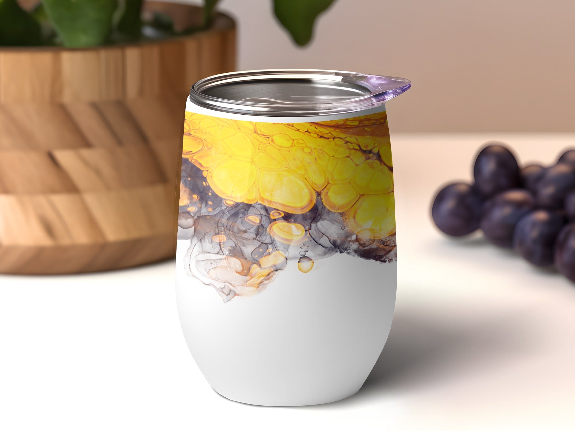 White tumbler with swirling yellow, gray, and black abstract art pattern.