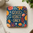 Coaster with "GOOD VIBES ONLY" text surrounded by colorful floral illustrations on a dark blue background.