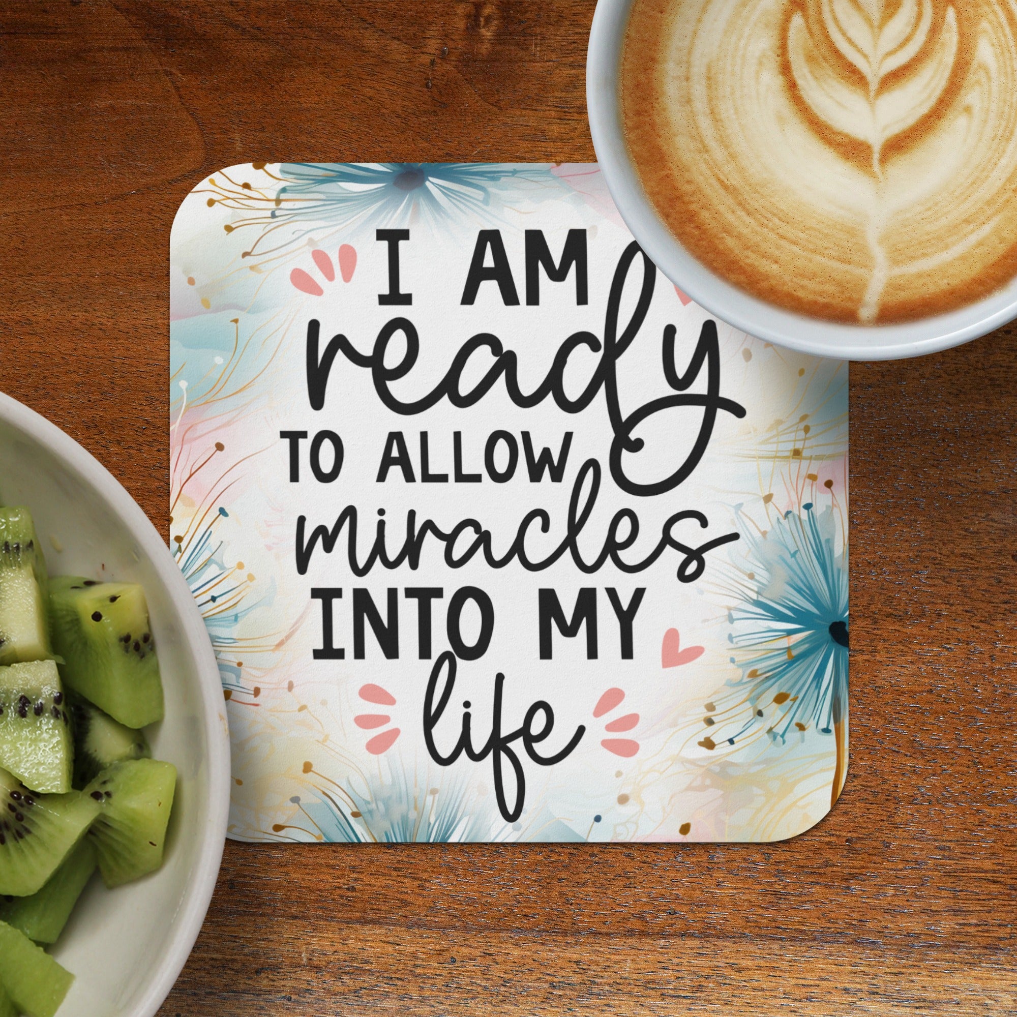 Coaster with "I am ready to allow miracles into my life" text, with fruit and coffee.