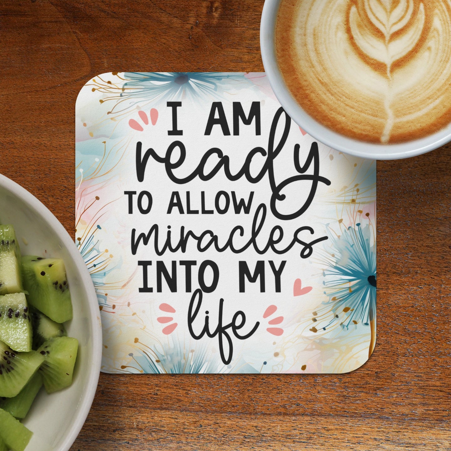 Coaster with "I am ready to allow miracles into my life" text, with fruit and coffee.